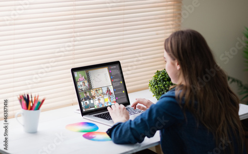 Caucasian woman using laptop for video call, with smiling diverse elementary school pupils on screen