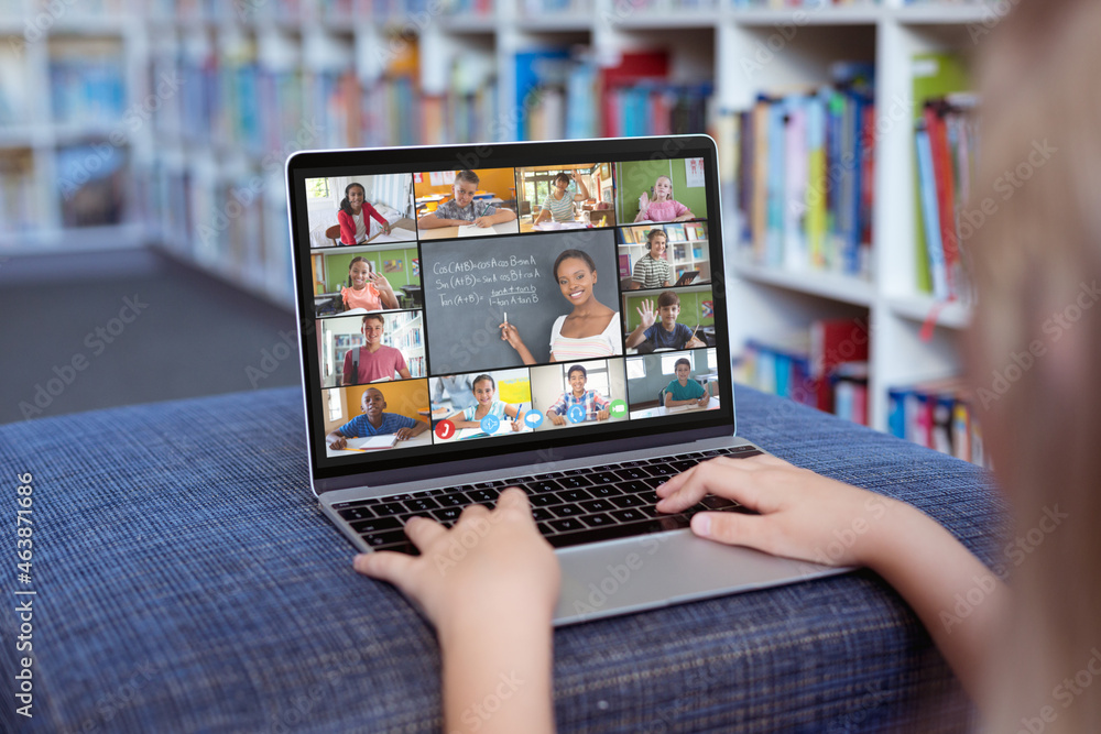 Caucasian girl using laptop for video call, with smiling diverse elementary school pupils on screen Caucasian girl using laptop for video call, with smiling diverse elementary school pupils on screen