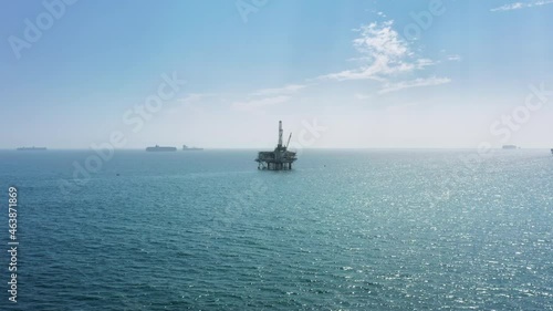 Flying towards American offshore oil drilling platform in the Pacific ocean at California coastline. Strategic political and economic region in USA. Gas and oil business company making money