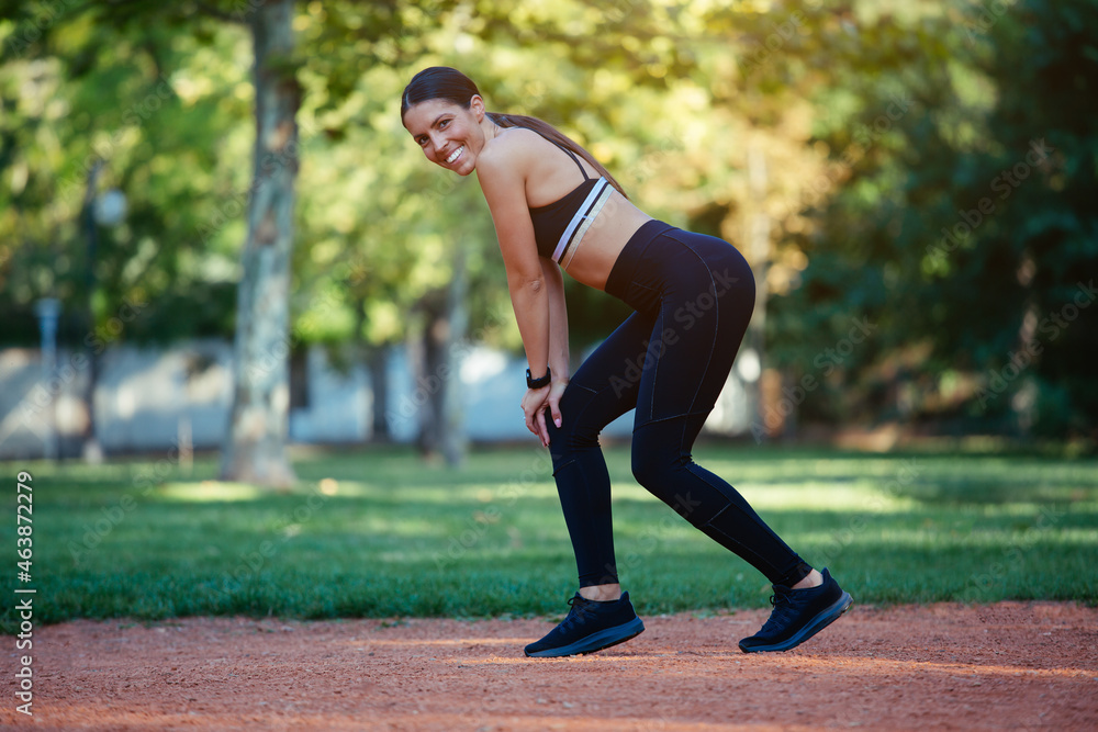 Young woman stretching body after jogging