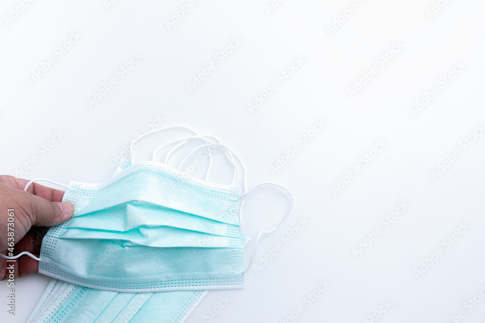 Hand man holding medical mask for protection virus isolated on white background with copy space. Concept wearing medical mask, and distance. Hand man holding medical mask for protection virus isolated on white background with copy space. Concept wearing medical mask, and distance.
