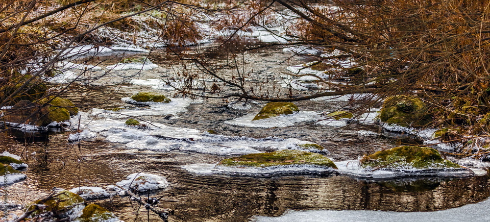 Fast river with ice in late autumn