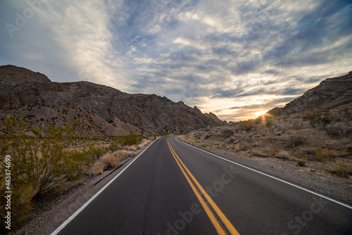 Driving down an empty road through the desert mountains