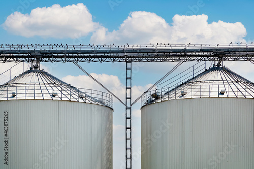 silver silos on manufacturing plant for processing drying cleaning and storage