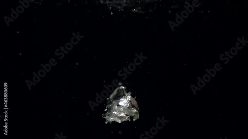 Slow motion air bubbles in water rising up to the surface on isolated black background. Slowmotion air bubbles floating under transparent water bubbles in aquarium