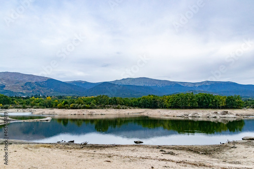 Reservoir. Views of a reservoir that reflects the landscape in the water on a cloudy day in Segovia, in Castilla y León, in Spain. Europe. Horizontal photography. 