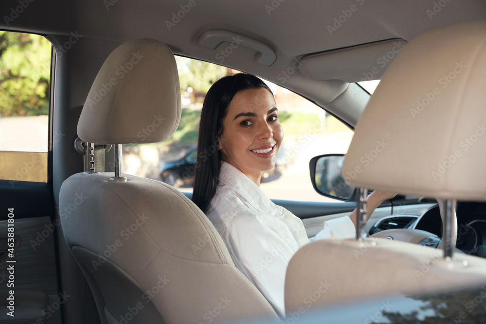 Beautiful young driver sitting in modern car