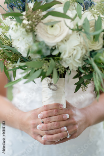 Beautiful wedding bouquet of white roses in the hands of the bride green wedding bouquet with eucalyptus in bride hands close up Ring with diamond on the bride's finger white wedding dress