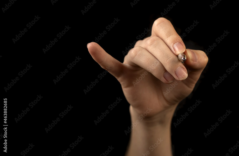 Hand with pen isolated on a black background. Concept of marking checklist, business work job drawing, mark pointing Hand with pen isolated on a black background. Concept of marking checklist, business work job drawing, mark pointing