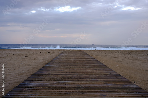 Wooden path leading to the beach  with the sea in the background.