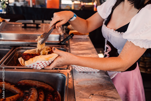 Woman puts sauerkraut on hotdog bratwurst