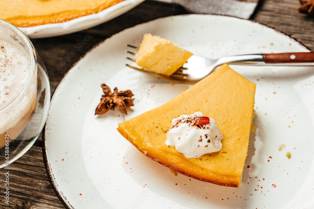 A slice of pumpkin cheesecake pie with whipped cream, Food recipe background. Close up A slice of pumpkin cheesecake pie with whipped cream, Food recipe background. Close up