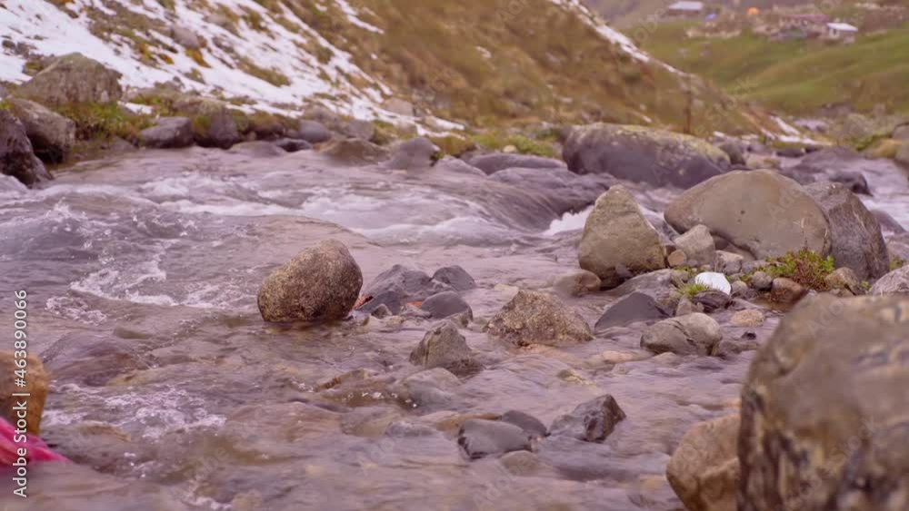 Clear mountain river , stream flowing through rocks. Close up of river stones with flowing water Clear mountain river , stream flowing through rocks. Close up of river stones with flowing water