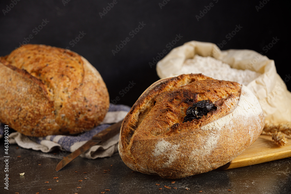 Rustic sourdough bread with tomato on a black marble table. Rustic sourdough bread with tomato on a black marble table.