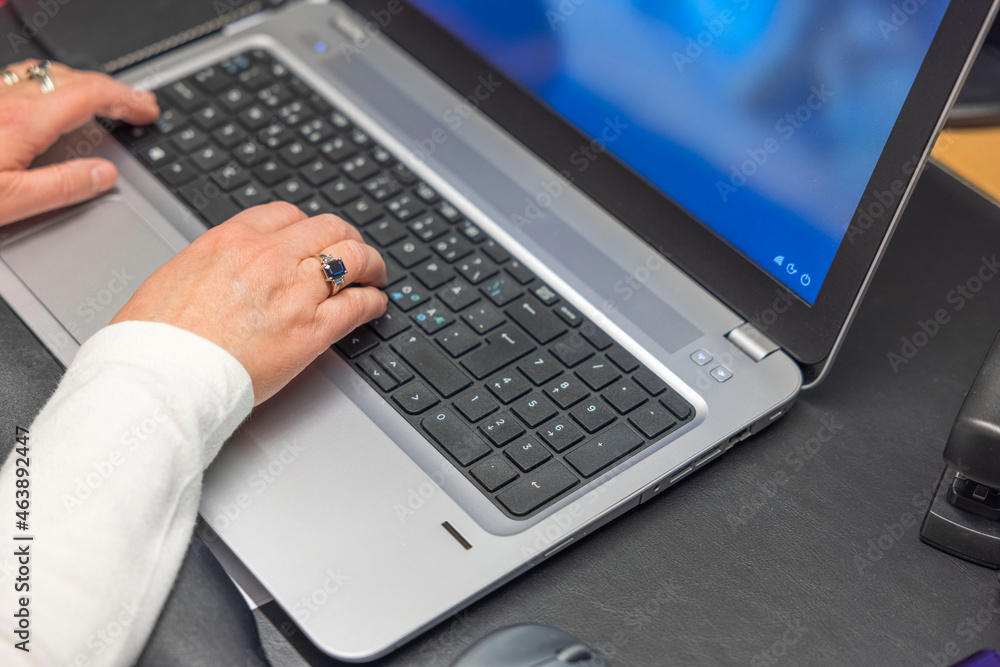 Close up view of female hands on notebook keyboard. Sweden. Close up view of female hands on notebook keyboard. Sweden.