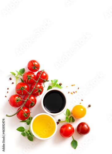 Various spices, tomatoes, olive oil and balsamic vinegar on a white background top view. Free space for text. Food background, ingredients for cooking. photo