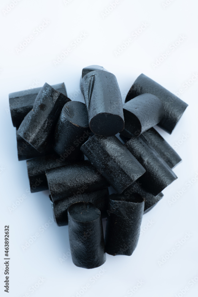 Closeup of a bunch of Finnish black licorice against a bright white background