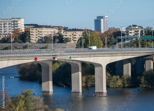 A bridge at the highway Essingeleden between the islands Essingen an colorful autumn day in Stockholm, Canoers passing the on the lake Mälaren