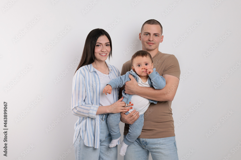 Portrait of happy family with little child on light background Portrait of happy family with little child on light background