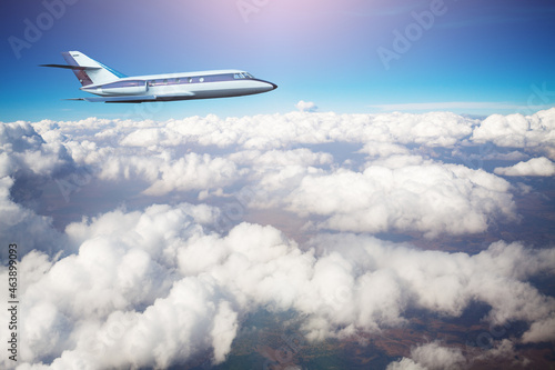 Business jet airplane fly above clouds in the sky