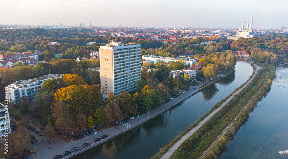Big hotel next to the Isar river seen from aerial drone view in south of Germany. Beautiful autumn landscape in Munich seen from above
