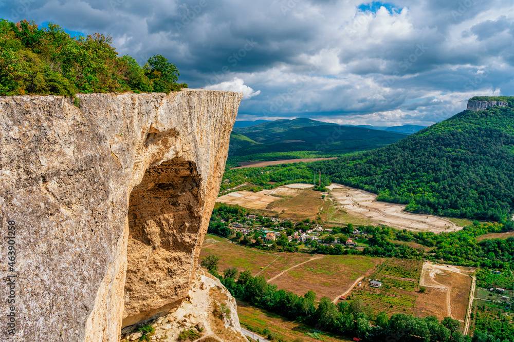 The edge of a high cliff, a mountain landscape with panoramic views of the valleys.