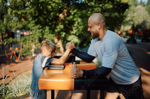 Father and son, arm wrestling exercise, playground