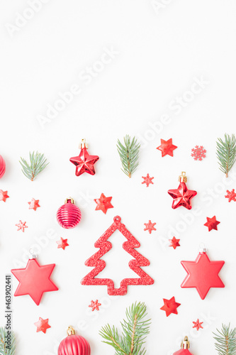 Flat lay pattern with fir branches, christmas balls and decorations on a white background