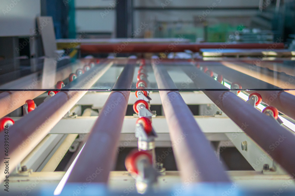 Obraz premium close up of glass sheet on rollers in glass factory