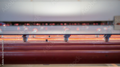 close up of glass sheet on rollers in glass factory