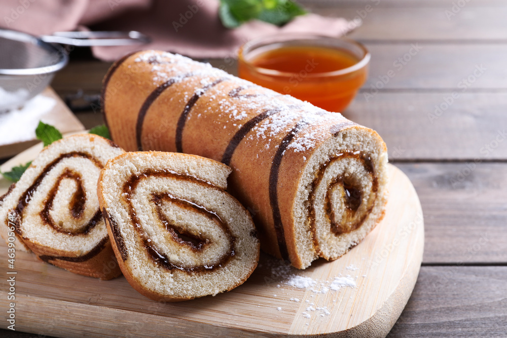 Fototapeta premium Tasty cake roll with jam on wooden table
