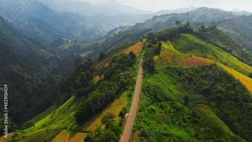 Aerial footage of winding road in rainy season on tropical rainforest mountain in Nan province, Thailand. 4K resolution drone footage top view.