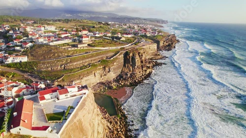 Scenic Aerial View of Praia das Azenhas do Mar Beach, Lisboa, Portugal in 4K. Sintra-Cascais Natural Park from above during sunset. Portuguese coastal village with traditional coloured houses. photo