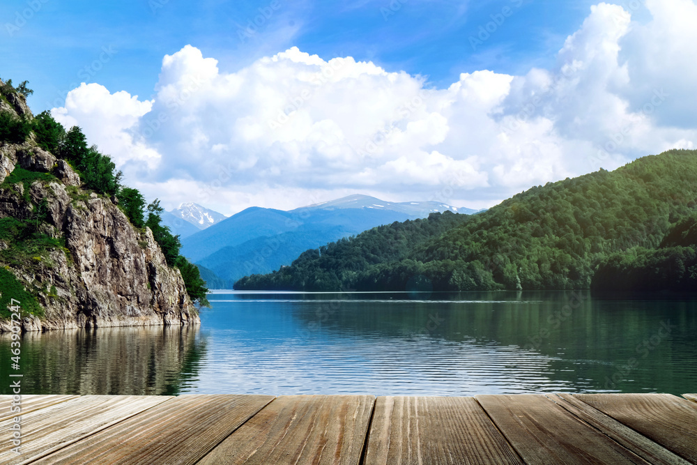 Beautiful view of mountains and wooden pier near river on sunny day Beautiful view of mountains and wooden pier near river on sunny day