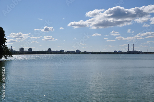 Panoramic view of the lake. Coastline with residential buildings and CHP pipes.