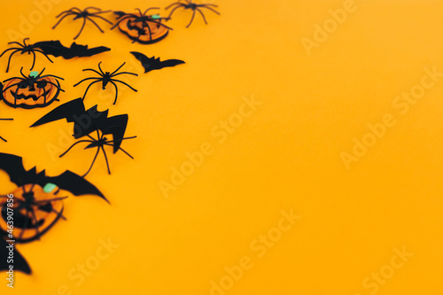 Happy Halloween. Modern pumpkins jack o lantern, spiders, bats border on orange background with space for text. Season's greeting card. Halloween decorations on yellow paper © sonyachny