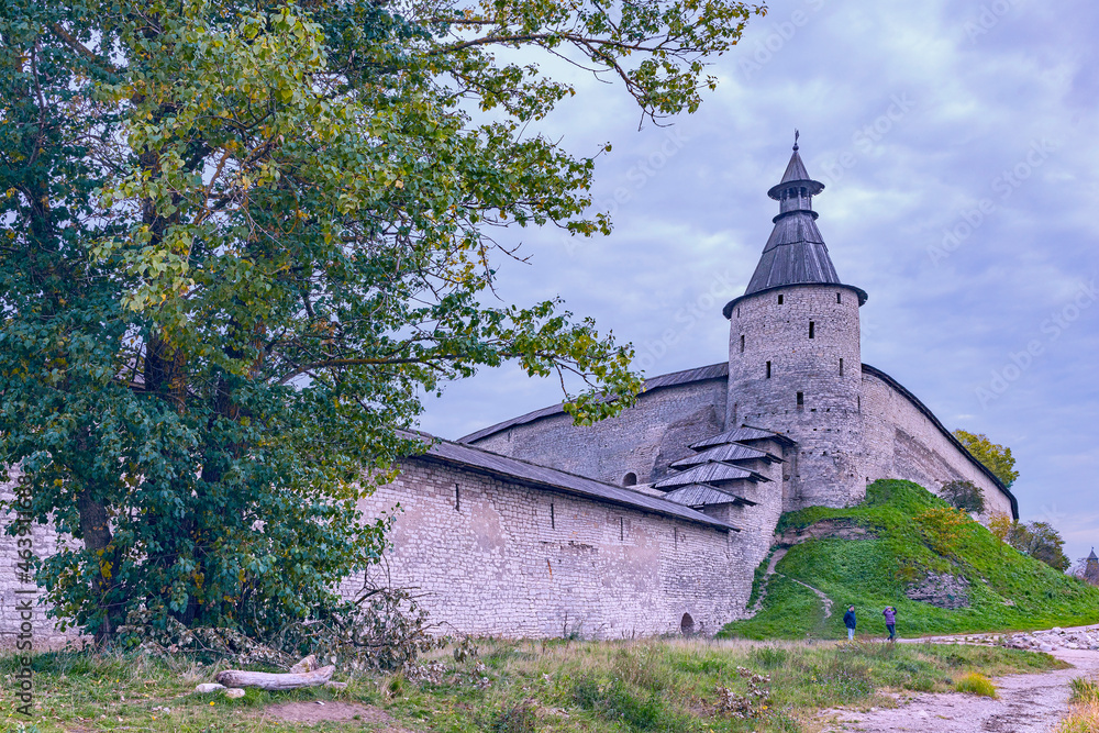 fragment of an old fortress wall with a corner watchtower in the ancient Russian city of Pskov