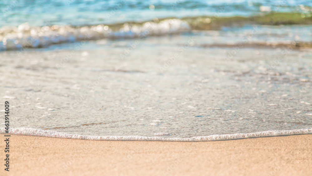 the waves of the sea on the sandy beach on a sunny day