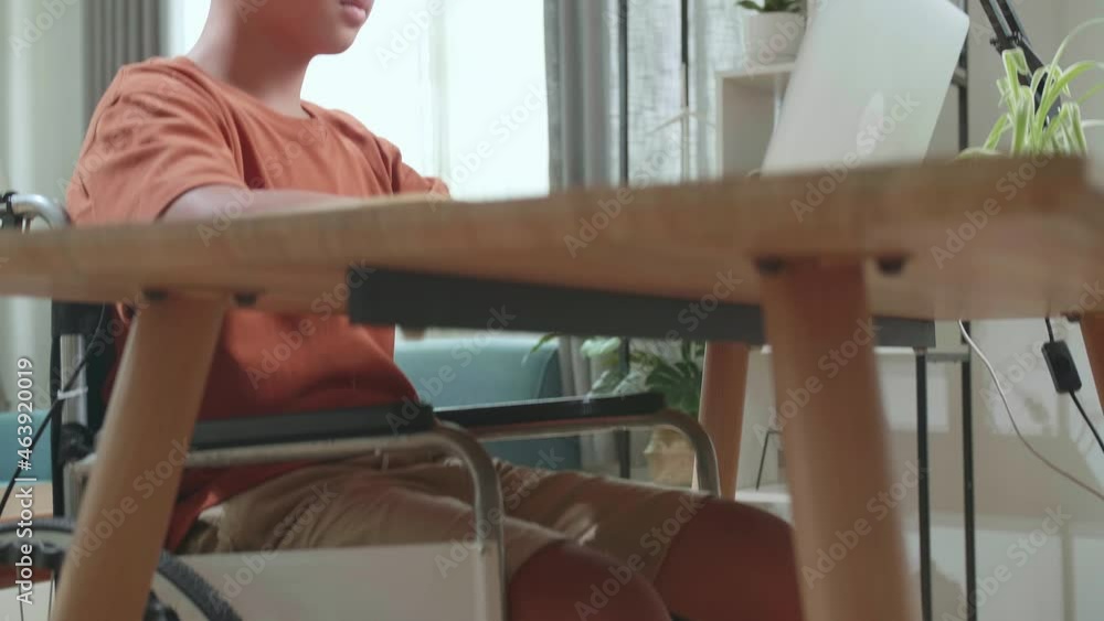 Upset Young Asian Boy Sitting In A Wheelchair While Using Laptop Computer At Home
Upset Young Asian Boy Sitting In A Wheelchair While Using Laptop Computer At Home