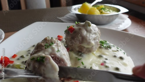 Eating meatballs with white sauce. Traditional German food called Koenigsberger Klopse. photo