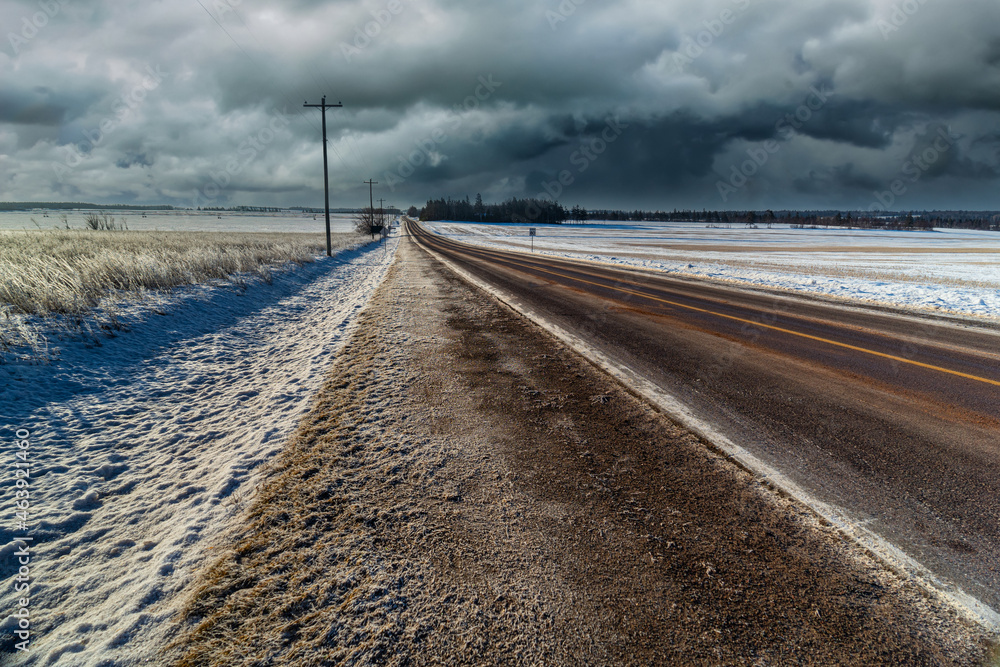 Asphalt highway traveling through a winter landscape.