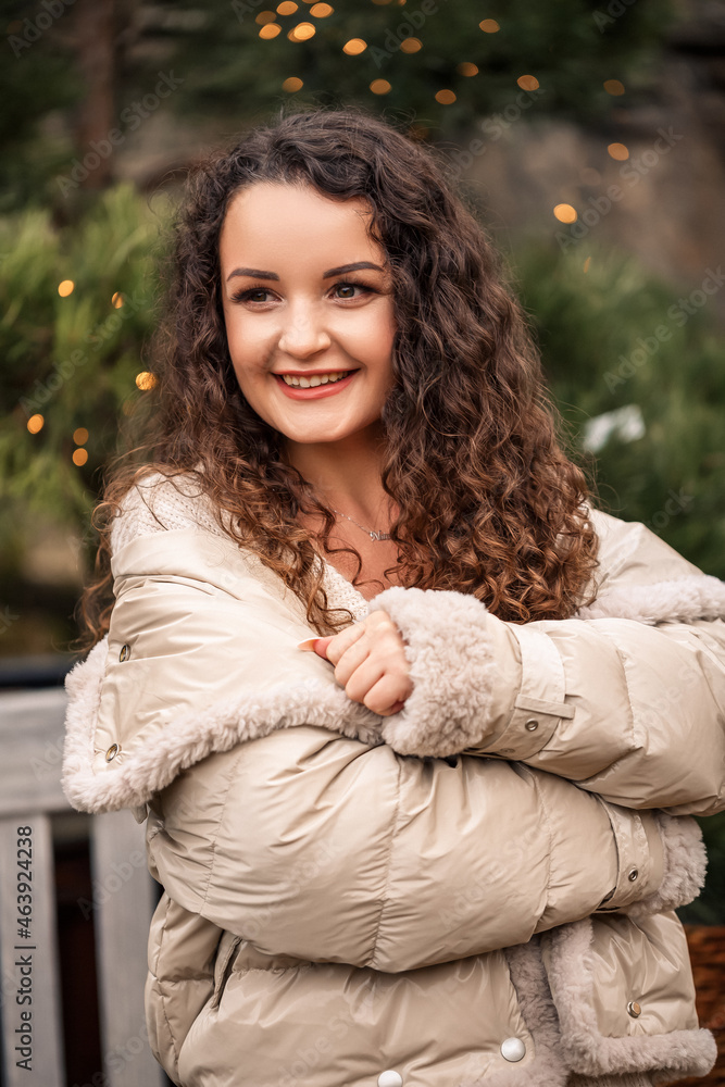 A cheerful girl walks among the trees and smiles, she has a New Year's mood A cheerful girl walks among the trees and smiles, she has a New Year's mood