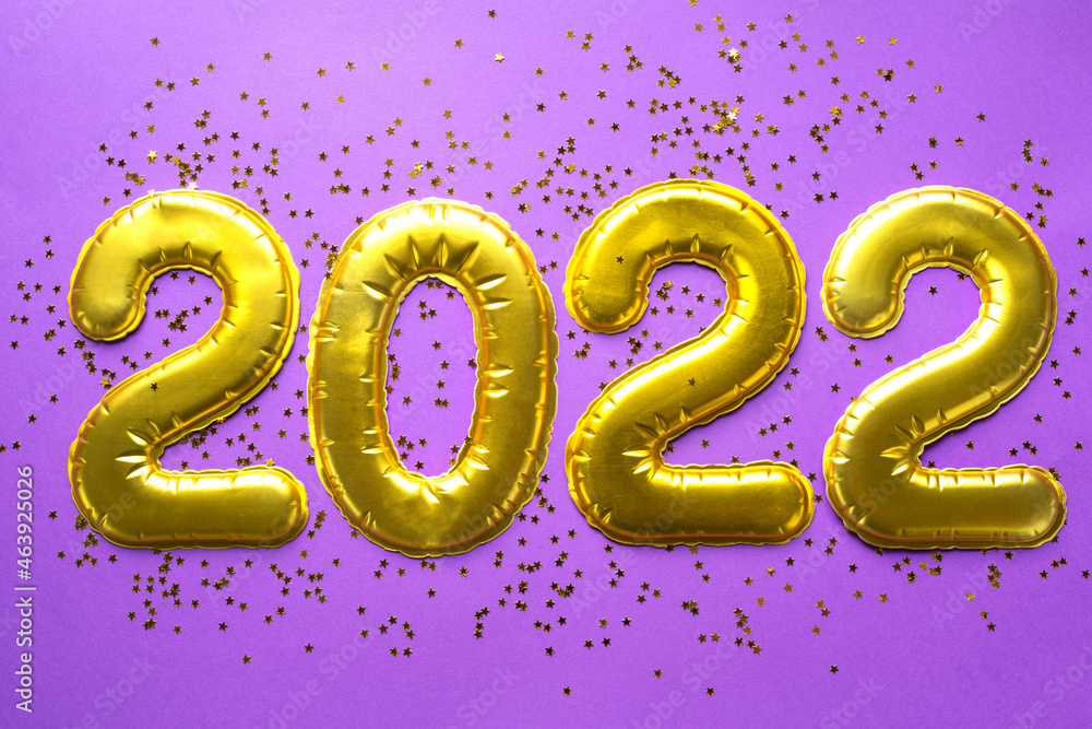 Happy New Year- golden numbers 2022 on a purple background with sequins, stars, glitter, lights of garlands. Greetings, postcard. Calendar, cover. Happy New Year- golden numbers 2022 on a purple background with sequins, stars, glitter, lights of garlands. Greetings, postcard. Calendar, cover.