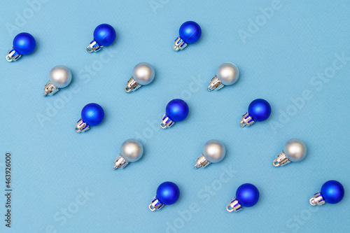 New year's composition. Christmas blue and silver christmas tree decorations balls on a blue background. Flat lay, top view, copy space