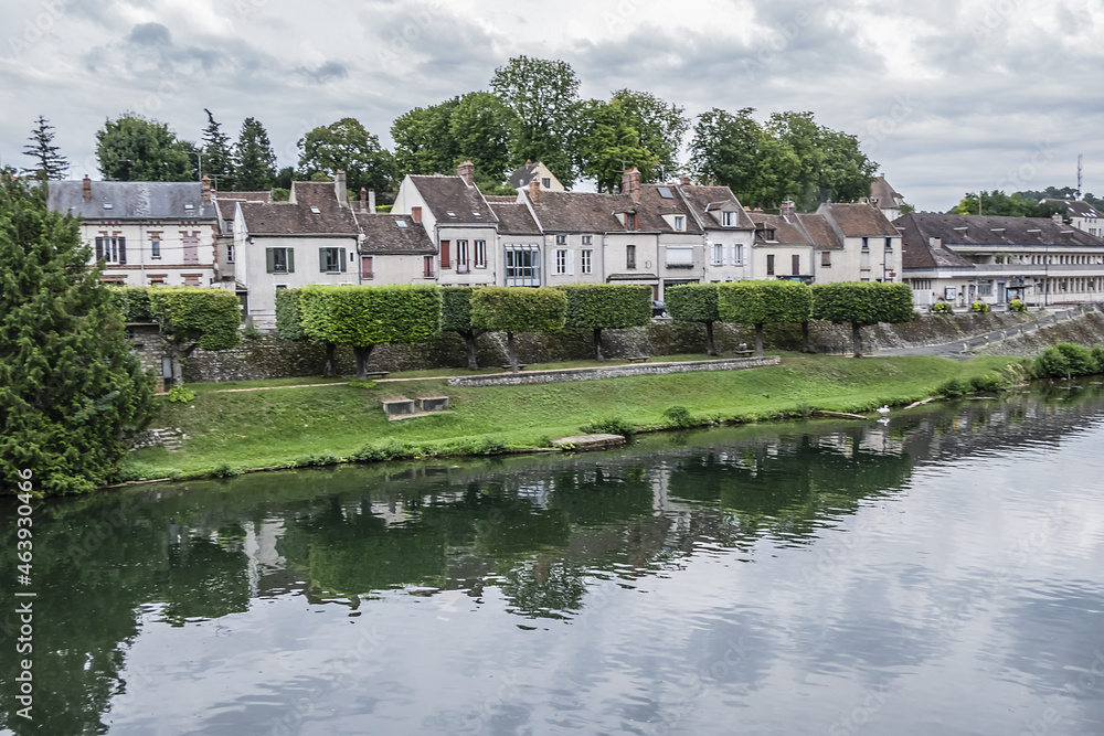 Fototapeta premium Loing river in Nemours and picturesque houses along the water. Nemours, Seine-et-Marne department, Ile-de-France, France.