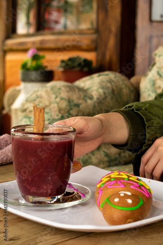 Woman's hand gently lifting a cup of the traditional ecuadorian drink 