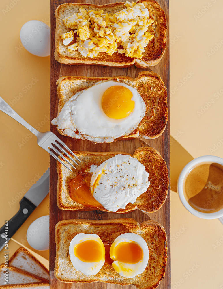 fried Toast bread with four different types of cooked chicken eggs, scrambled eggs, fried eggs, poached egg and creamed egg. Breakfast of chicken eggs.