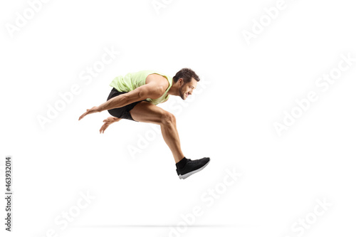 Full length profile shot of a male athlete performing a long jump