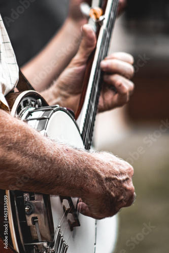 Mature adult Banjo bluegrass Band playing in outdoor concert with vertical close-up of hands photo