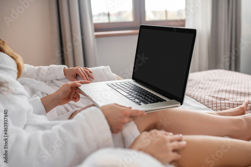 Female hands holding open laptop on bed © zinkevych